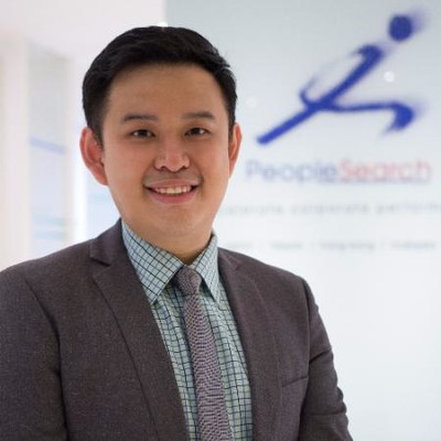 PeopleSearch consultant Tan Kok Pin standing in front of PeopleSearch signboard