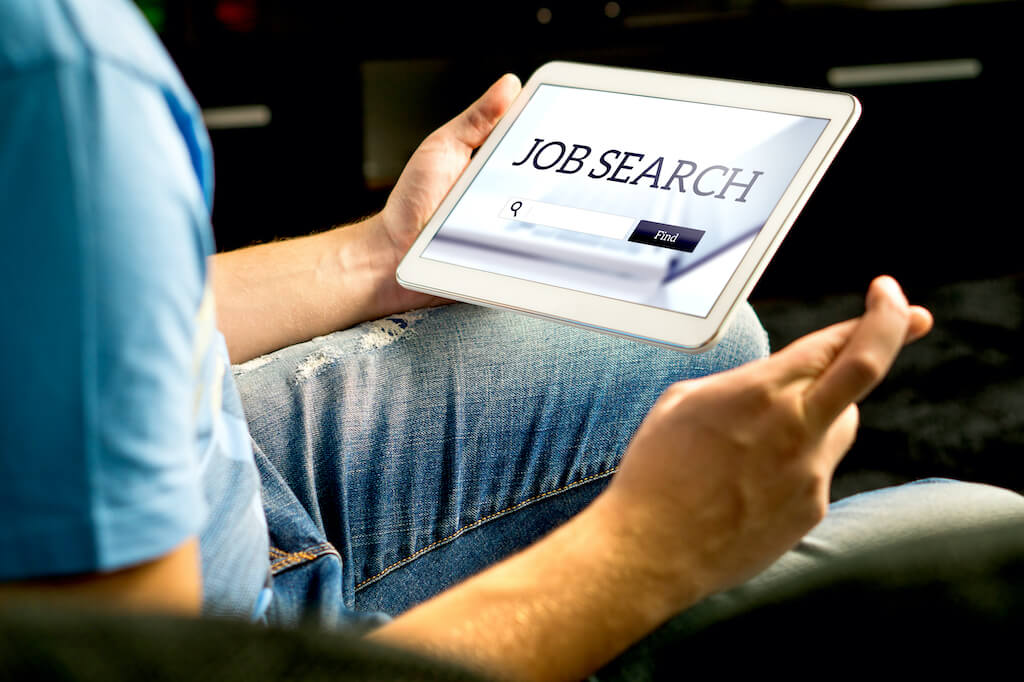 Man holding ipad showing job search page
