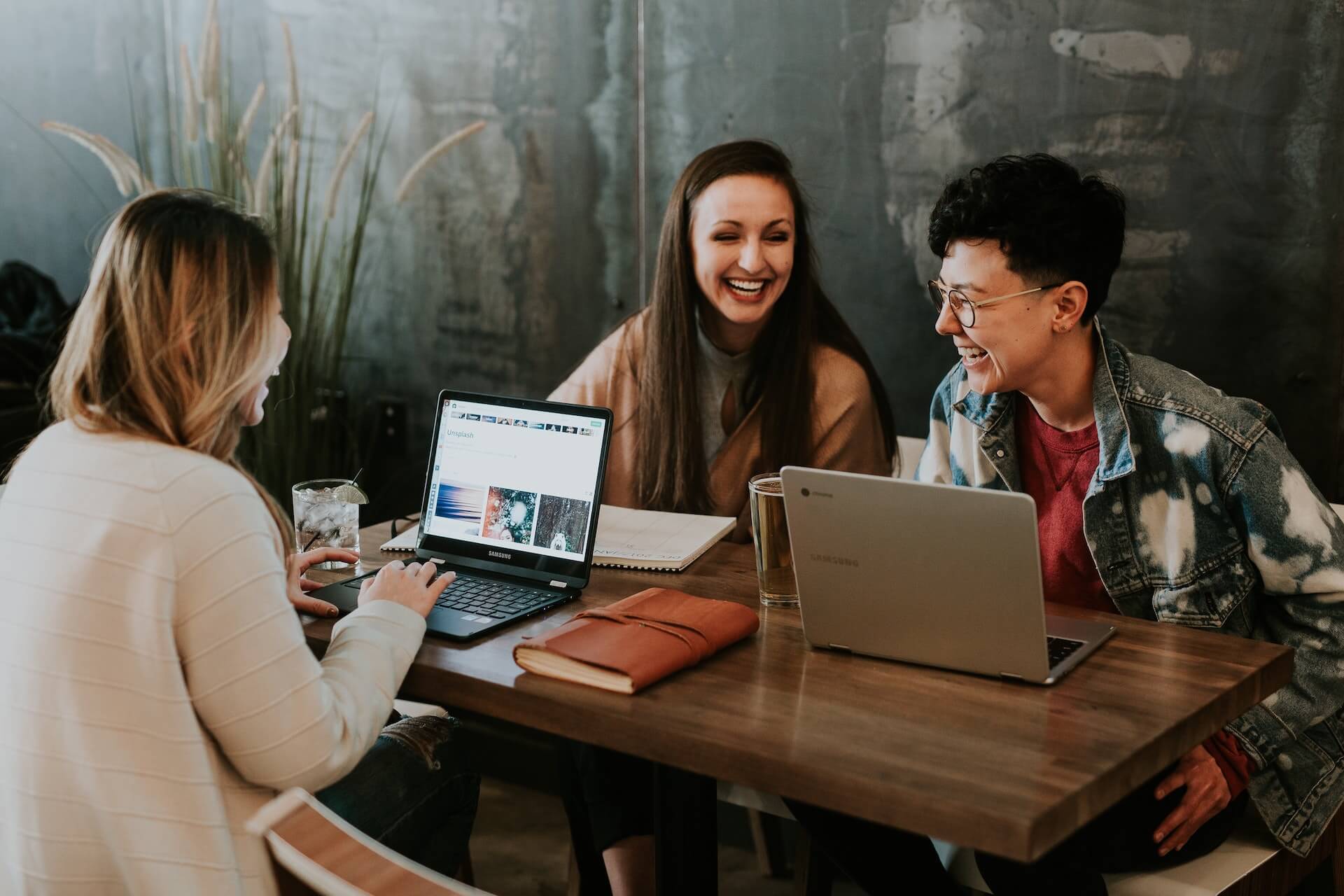 Professionals with laptops talking and working at desk